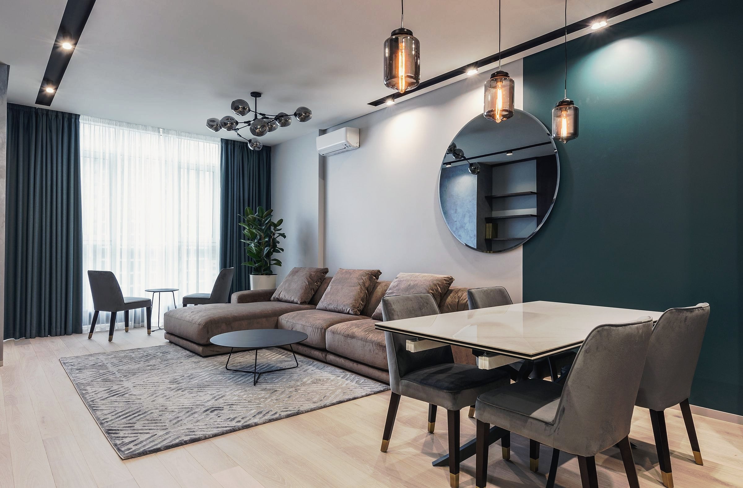 A contemporary living and dining room with a large sofa and a wooden table.