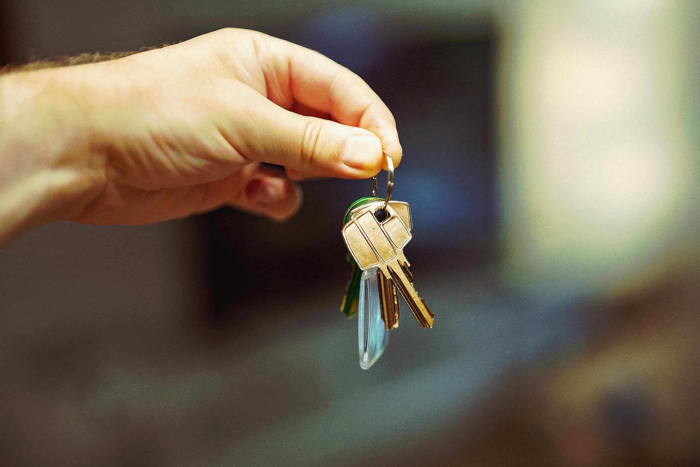 A hand holding up a ring of house keys.