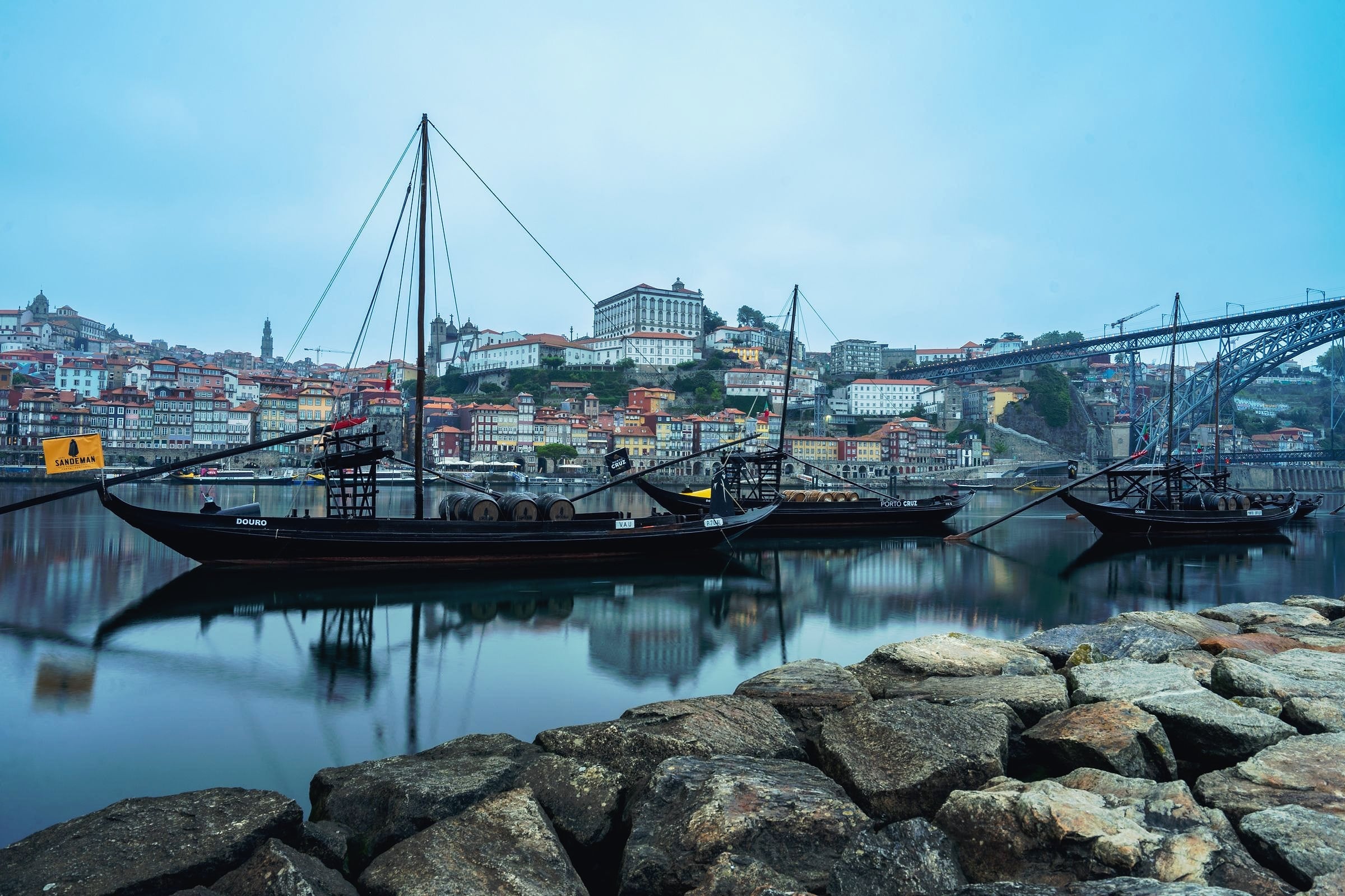 Traditional rabelo boats, once used to carry port down the Douro, moored in front of Porto's riverside.